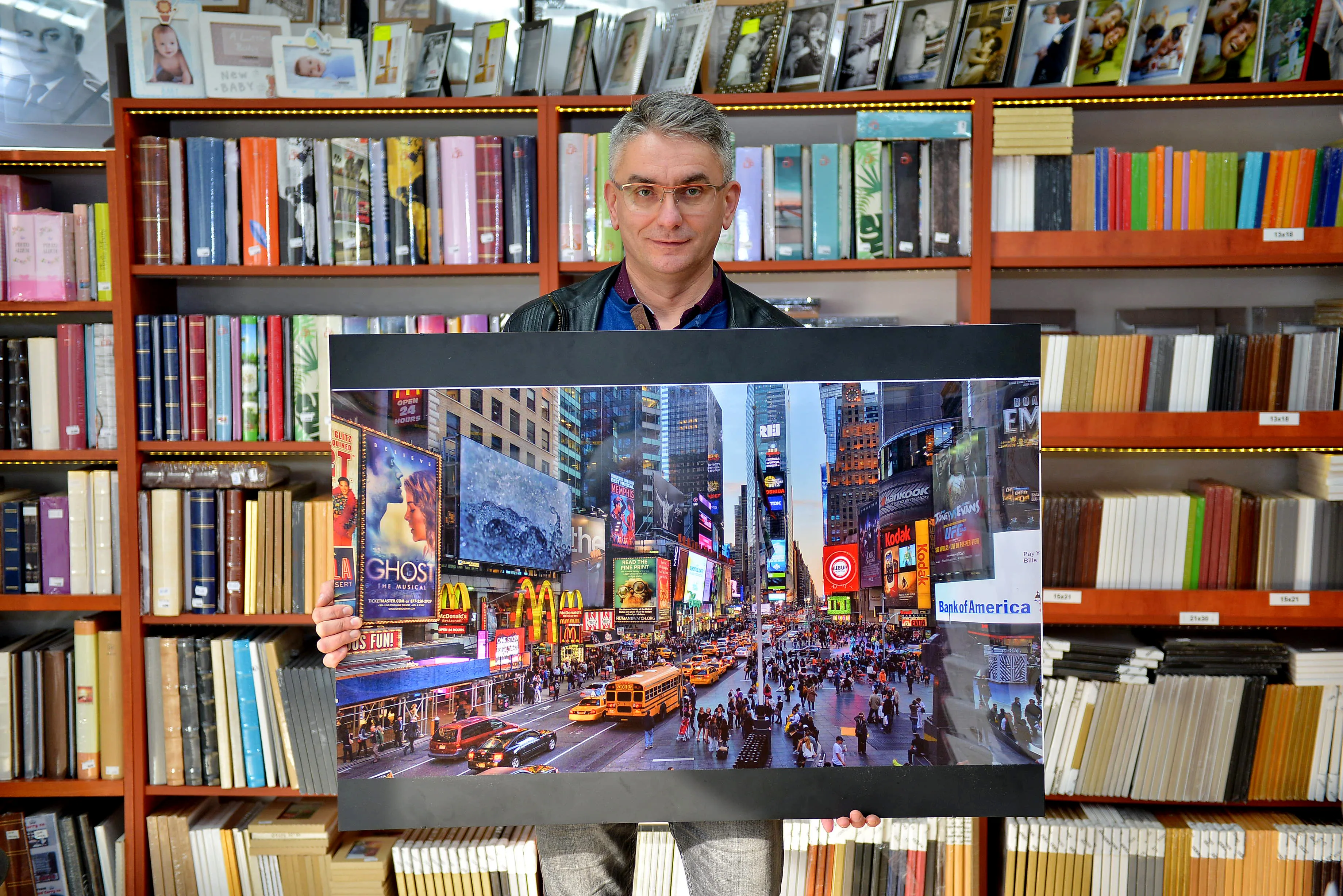 Właściciel trzymający inne wydrukowane zdjęcie na dużym formacie